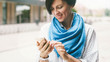 © JKstock - Young attractive woman wearing white shirt is reading messages on the mobile phone while standing on a street. A hipster girl is chatting online by a smartphone internet.