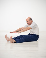 Wall Mural - Elderly man practicing yoga or fitness. Positive mood on sports activities