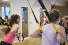 Women In Exercise Class Doing Suspension Training