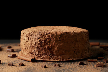 Sticker - Tasty chocolate cake with cinnamon on black background