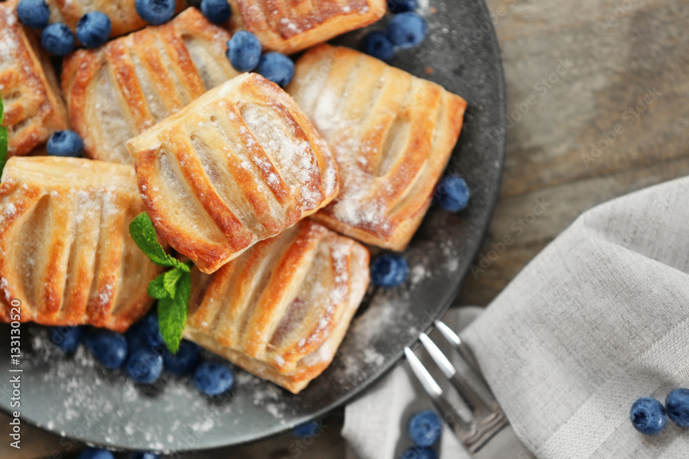 Sweet tasty pastries with bilberries on plate, closeup