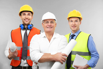 Wall Mural - Senior engineer and workers on light background