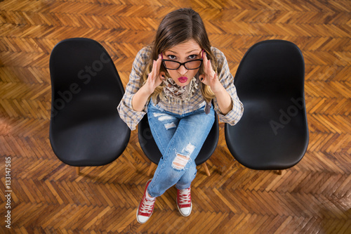 Fotografie, Obraz Portrait of modern young businesswoman sitting on the chair in her office and ma