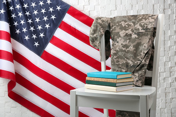 Wall Mural - Chair, books, soldier uniform and USA flag near light textured wall. Military education concept