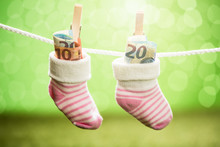Pair Of Baby Sock With Dollar Hanging On Rope