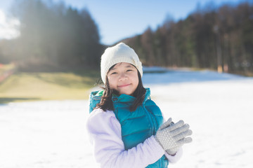 Canvas Print - Happy asian girl smiling outdoors in snow on cold winter day