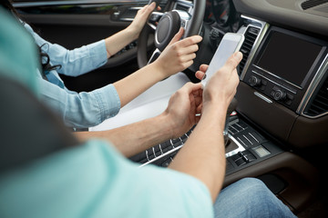 Wall Mural - happy man and woman with smartphone driving in car