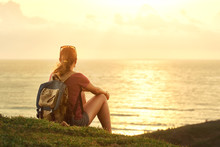 Young Girl With Backpack Enjoying Sunset Listening To Music On P