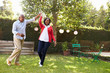 © Monkey Business - Senior black couple dance in their back garden, full length