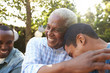 © Monkey Business - Senior man greeting his two adult sons in garden, close up