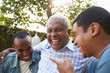 © Monkey Business - Senior man talking with his adult sons in garden, close up