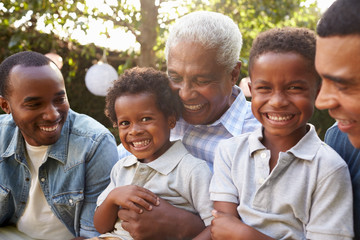 Wall Mural - Multi generation male family members gathered in a garden