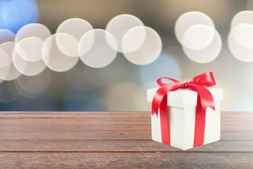 Poster - Gift box on wood texture with circle light bokeh background