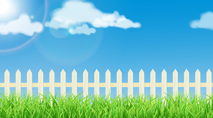 Spring theme - fresh grass, white wood fence and a sunny sky