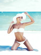 © Acronym - Beautiful girl in a bikini posing on the beach