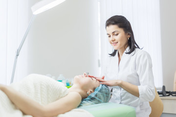 Woman receiving cleansing therapy. face massage