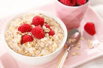 Wall Mural - Healthy and natural breakfast, oatmeal and raspberries in a bowl