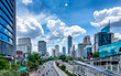 Beautiful skyline of Jakarta, Indonesia. Showing modern skyscraper buildings and beautiful blue sky and white cloud at daylight and big road with moderate traffic. Captured in Jend. Sudirman Street.
