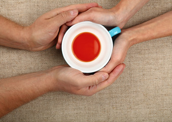 Wall Mural - Man and woman hands hold empty black tea cup