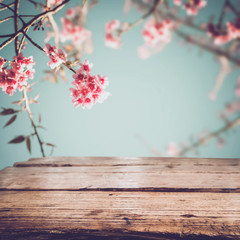 Wall Mural - top of wood table with pink cherry blossom flower (sakura) on sky background in spring season - empt
