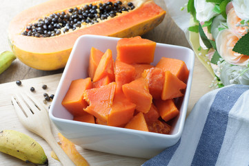 Wall Mural - kitchen table with slice fresh papaya on wood plate, healthy eating and dieting food, concept of health care, Image focus top view.