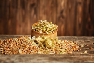 Canvas Print - Hop in bowl and barley on wooden background