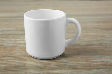 Poster - Blank ceramic cup on wooden background