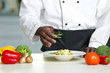 © Africa Studio - African American chef cooking tasty salad in kitchen, closeup