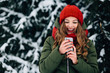Smiling girl with smartphone. Happy young girl in red winter hat and scarf using smartphone and smiling. Communication concept