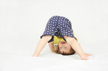 Wall Mural - Happy little girl standing on head upside down