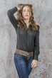 © rogkoff - Young girl with curly hair in a black shirt, jeans and high boots cowboy western style