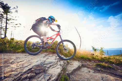 Female mountain biker riding, cycling MTB bike during sunny day in