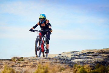 Wall Mural - Female MTB biker, riding downhill on rocks