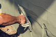 Construction worker holding plastering trowel smoothing wall defects
