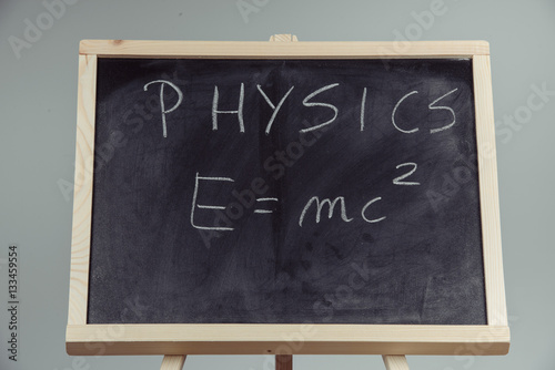 Physics word and formula E=mc2 on chalkboard Poster