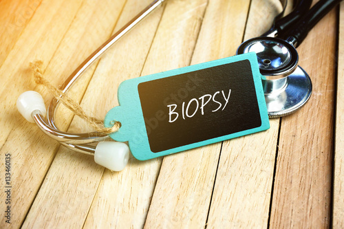Fotografia, Obraz Stethoscope and Wooden Tag Written With Biopsy on Wooden Background