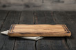 Empty cutting board with cloth napkin on wooden table