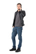 © sharplaninac - Serious casual young man in jeans and leather jacket talking on the cellphone. Full body length portrait isolated over white background.