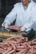 © WavebreakmediaMicro - Butcher packing raw sausages