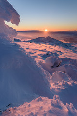 Poster - Frozen pink figures - beautiful winter landscape on a mountain top at sunset