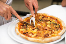 Woman Cutting Pizza With Cheese, Ham And Pineapple. Hawaiian Pizza.