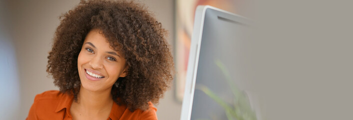 Wall Mural - Cheerful businesswoman working on desktop computer