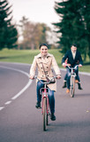 Fototapeta Miasto - Beautiful smiling woman riding bicycle