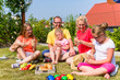 © Kzenon - Family having picnic in garden front of their home