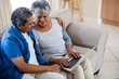 Senior couple using laptop in living room