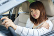 Young woman massaging her arm or shoulder while driving a car