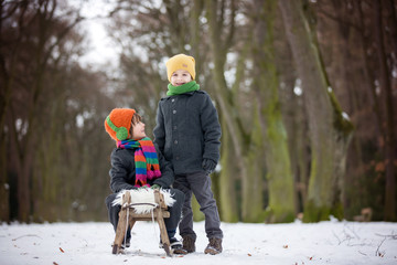 Canvas Print - Two Happy little children, boys, playing outdoors in snowy park