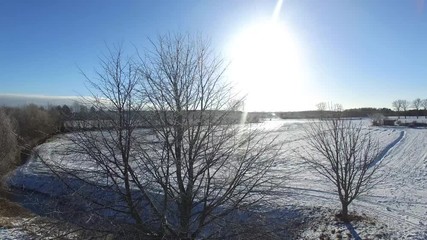 Wall Mural - aerial view  fly over beautiful snowy landscape with sun and blue sky in germany - dronen flight