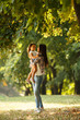 © BalanceFormCreative - Mother holding her daughter and playing around the park on beautiful morning.
