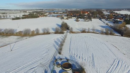 Wall Mural - aerial view fly over snowy landscape with blue sky in germany - dronen flight